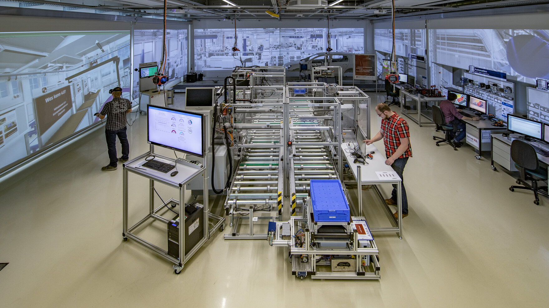 Produktionshalle mit drei Arbeitern in einer digitalen Umgebung